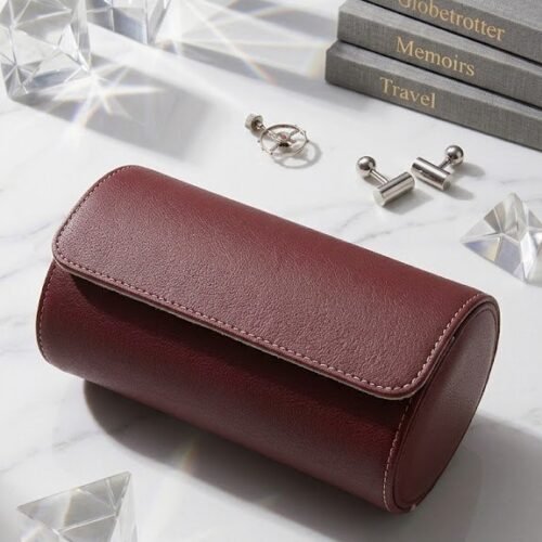 2-slot burgundy saffiano leather watch roll, closed, on a marble surface