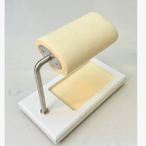 White watch display stand with a cream-colored cushion and accessory tray