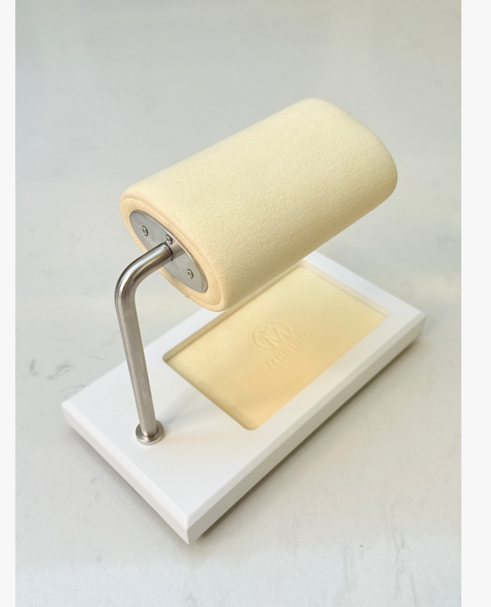 White watch display stand with a cream-colored cushion and accessory tray